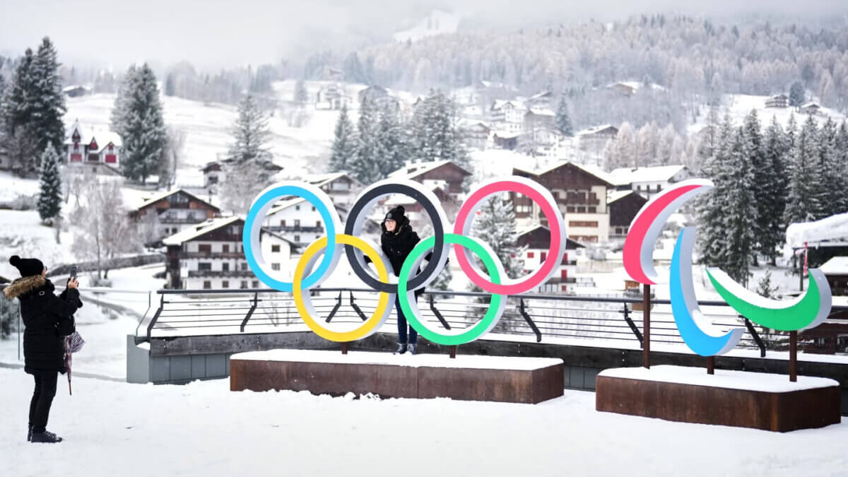 People take photos in ffront of the Milan Cortina Olympics and Paralympics rings on November 20, 2025.