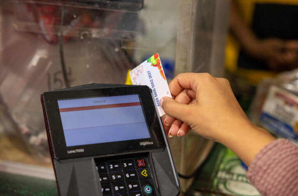 A shopper who receives SNAP benefits slides an EBT card at a checkout counter in a Washington, D.C., grocery store in December 2024.