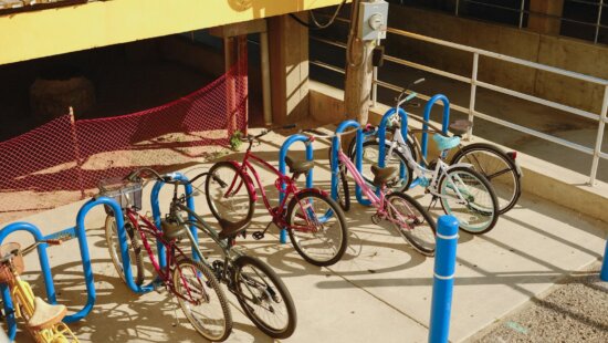 A group of bicycles parked on a sidewalk.