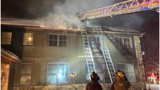 Responders work the roofline of a structure in Oakley on Dec. 29, 2025, after an interior fire spread into the attic and roof area.