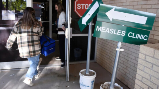Health department staff members enter the Andrews County Health Department measles clinic carrying doses of the measles, mumps and rubella vaccine, Tuesday, April 8, 2025, in Andrews, Texas. (AP Photo/Annie Rice, File)