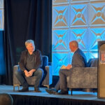 Matthew Prince speaks with Utah Gov. Spencer Cox during an onstage conversation at the Utah AI Summit in Salt Lake City on Dec. 2, 2025.