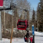 Park City Mountain employees support a woman after her ski boot became trapped in the doors of a Red Pine Gondola cabin, leaving her hanging upside down near the Canyons Village loading area on New Year’s Eve.