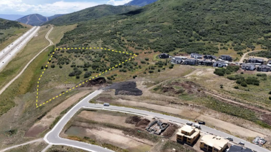 An aerial view shows the Clark Ranch hillside near Quinn’s Junction, with a yellow dashed outline marking a proposed 10-acre development footprint discussed by Park City officials and planning commissioners.