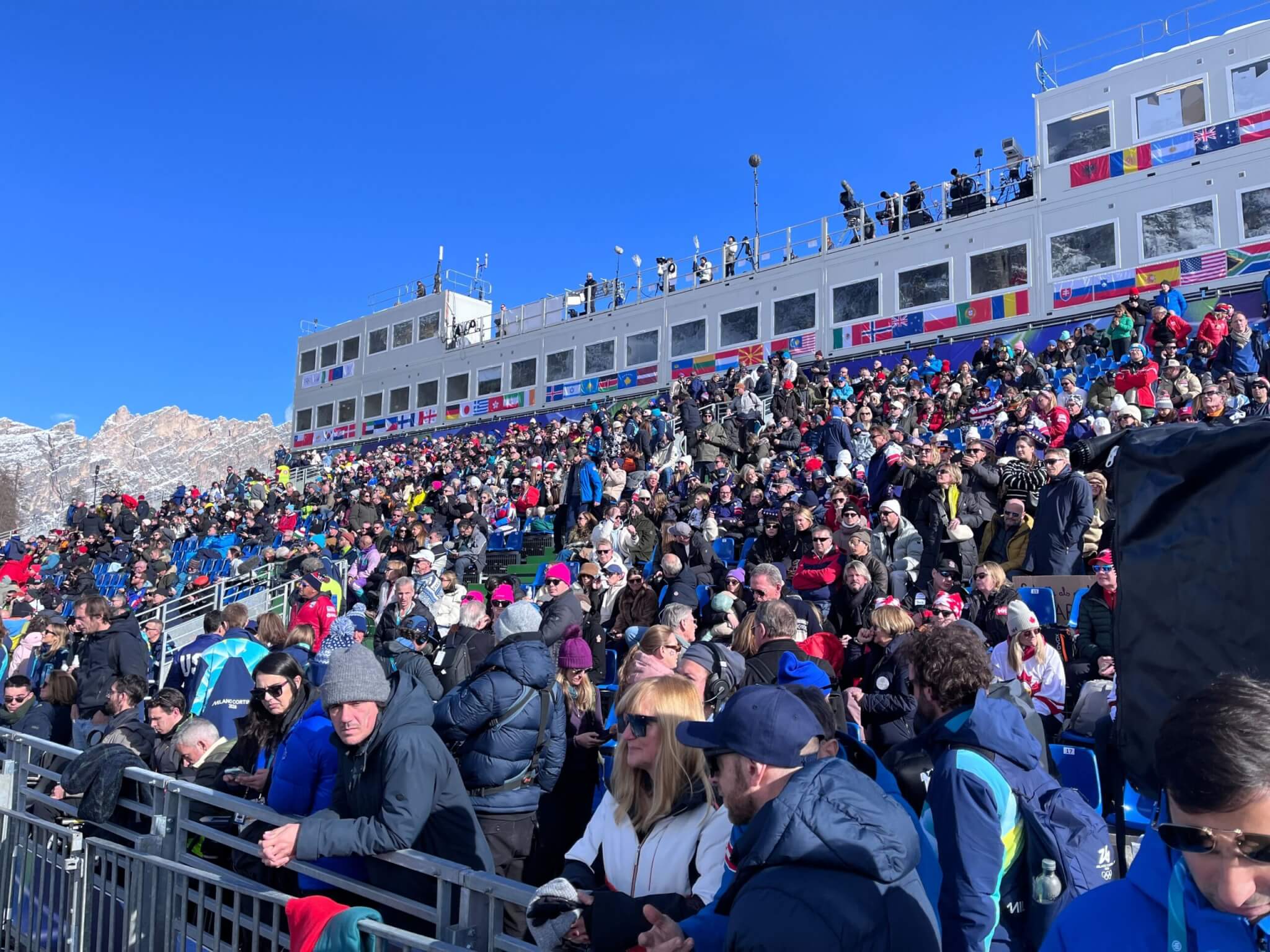 Fans cheer from the stands along the Olimpia delle Tofane course during the women's downhill at the Milano Cortina 2026 Winter Olympics in Cortina d'Ampezzo, Italy