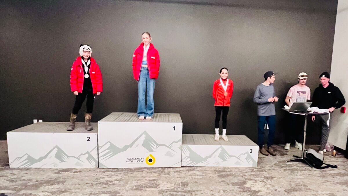 (L-R) Park City Ski & Snowboard athletes Lomax McCrank, Andie Brown, and Daisy Schmidt on the all-girls podium of a race announced by Billy Demong and worked on by Eric Camerotta, alongside coaches Adam Loomis, Casey Larson, and Stephen Schumann. Olympians putting medals around the necks of nordic combined and ski jumping competitors on Saturday.