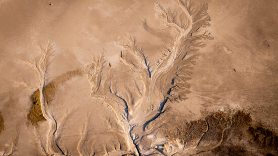 Patterns left behind by draining water are shown in mud flats surrounding the Great Salt Lake near Magna on Tuesday, Aug. 5, 2025.
