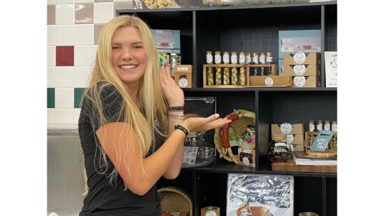 Lace poses with Park City PUPU products at a local retail display. The boutique organic candy line, which she co-founded at age 15, is inspired by the moose that wintered in her family's backyard for nearly two decades.