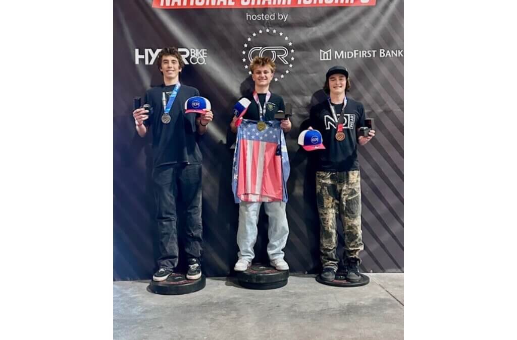Samuel McKenzie, center, stands atop the podium after winning the Amateur 14-18 division at the 2026 USA Cycling BMX Freestyle National Championships at COR Park in South Jordan.
