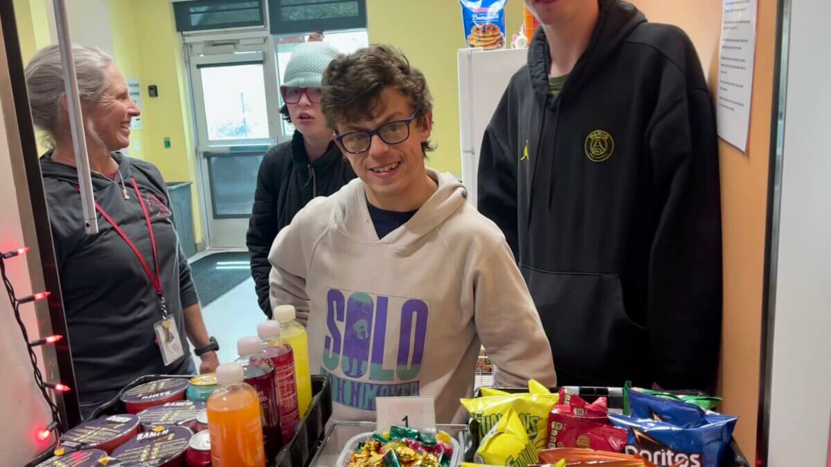 Three of the Transition program students managing the school snack store alongside their teacher, Jen Ward.