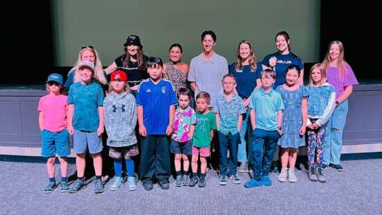 Get Out And Play athletes in front, along with Program Director Heather Sims and Olympians with former YSA athletes/elite global competitors.