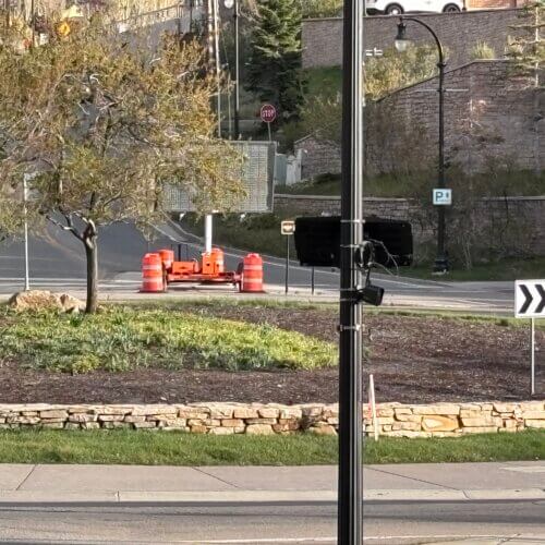 A Motorola license plate reader at the Marsac Avenue roundabout near Old Town Park City. The camera, visible on the standard streetlight pole at the center of the frame, scans every vehicle entering or leaving the historic district.