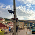 A Motorola license plate reader mounted on a pole near the corner of State Route 224 and Main Street in Park City, with Old Town in the background.