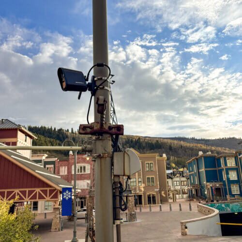 A Motorola license plate reader mounted on a pole near the corner of State Route 224 and Main Street in Park City, with Old Town in the background.