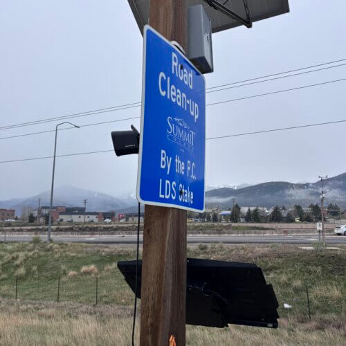 A Motorola license plate reader on Rasmussen Road in Summit County, mounted on a utility pole alongside community signage.