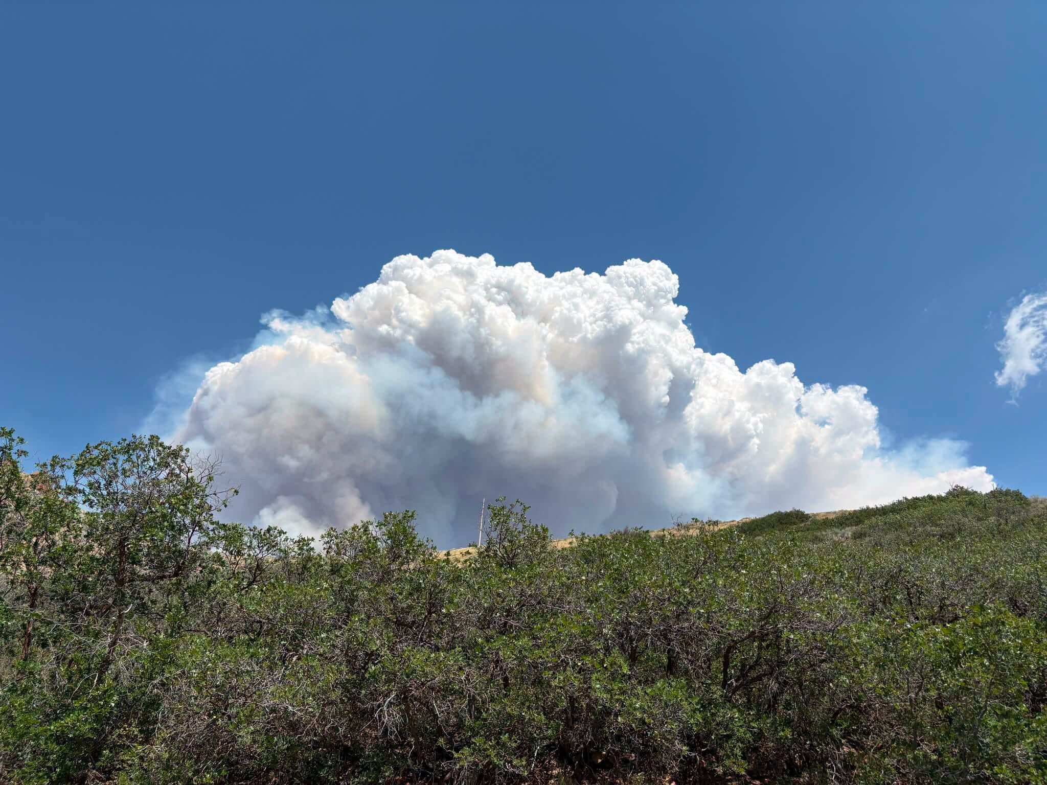 A large smoke column billows from the Rocky Canyon Fire on Sunday, Aug. 9, 2026, as the fire expands on its northeast side toward Henefer. The fire has spotted across SR-65 and prompted new evacuation orders for areas south of Henefer.