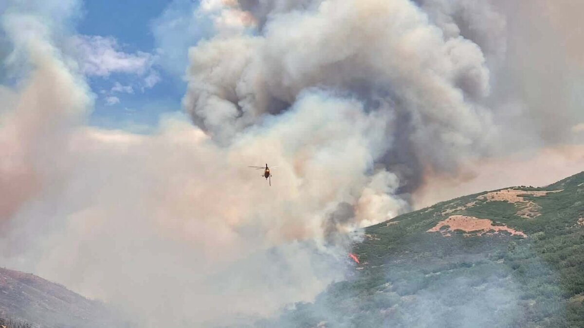 A helicopter conducts water bucket operations over the Rocky Canyon Fire on Saturday, Aug. 8, 2026. The fire grew to an estimated 2,800 acres overnight with 0% containment, and crews are using aviation resources along with dozers and hand crews to secure the fire perimeter.
