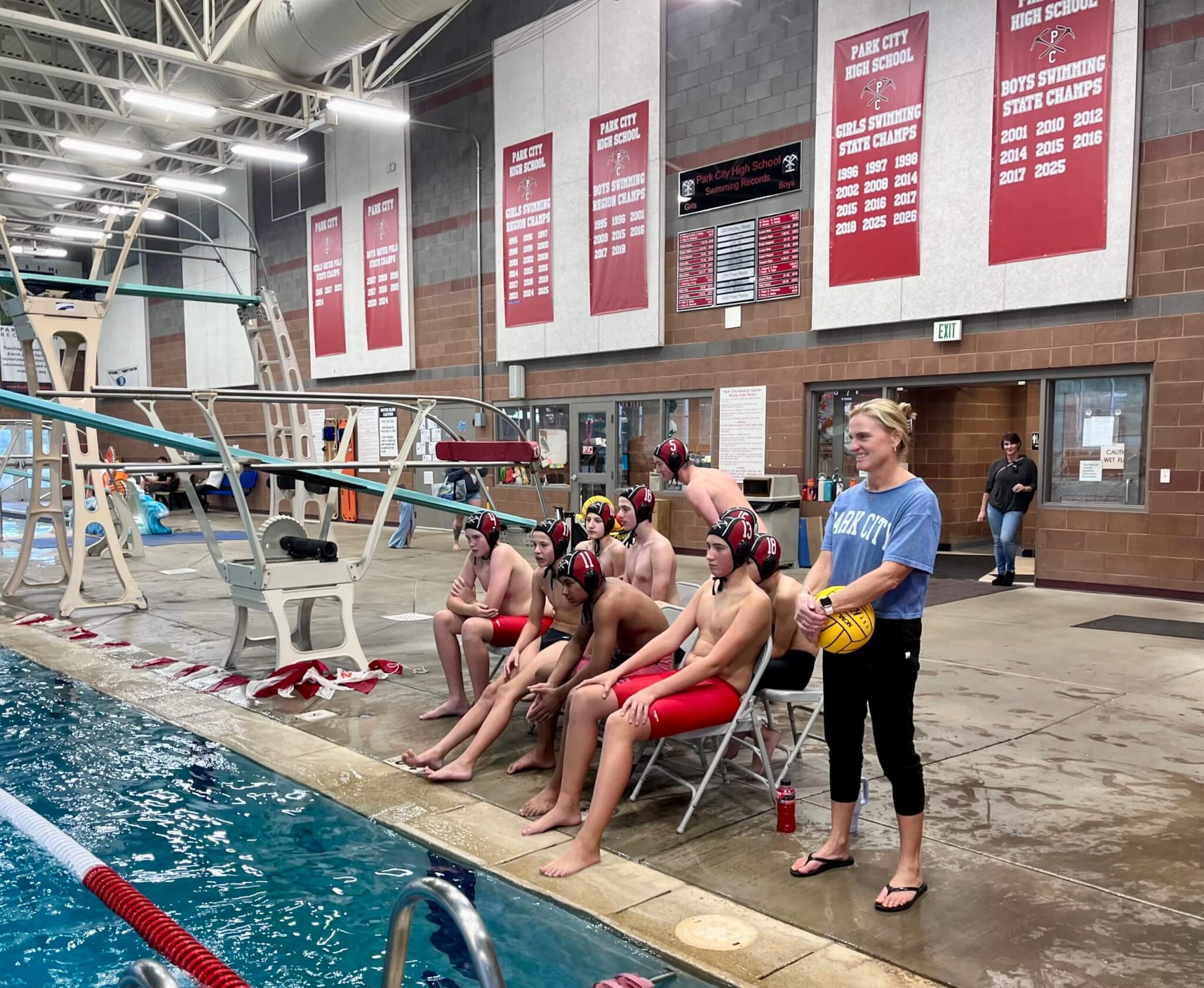 Coach Heather Flynn alongside members of the Water Polo Team at the Park City Aquatic Center during a scrimmage.