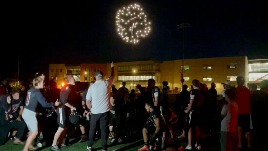 Coach Cunninham points to the fireworks telling his team to enjoy the show, and that they'd earned the Homecoming celebration.