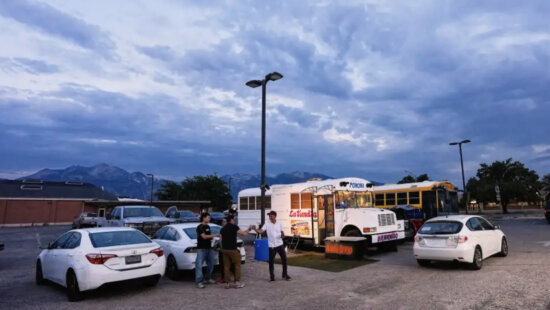 Venezuelan Jadiel Rodriguez greets people in front of his school bus turned store, catering to Venezuelan products Tuesday, July 14, 2026, in Midvale, Utah.