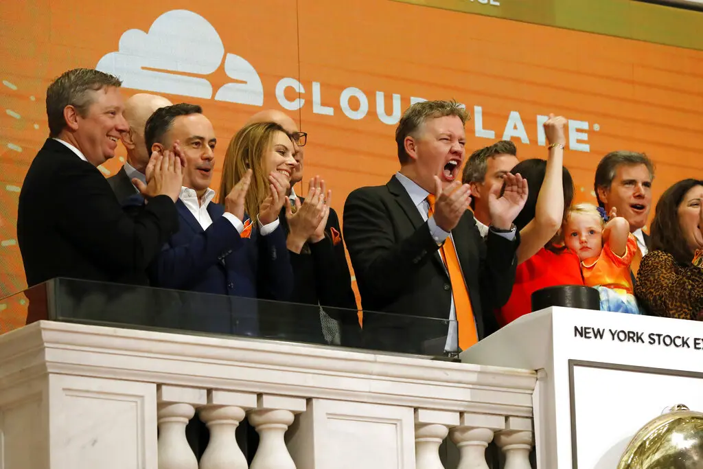 Cloudflare co-founder and CEO Matthew Prince, right center, applauds during New York Stock Exchange opening bell ceremonies to celebrate his company's IPO.